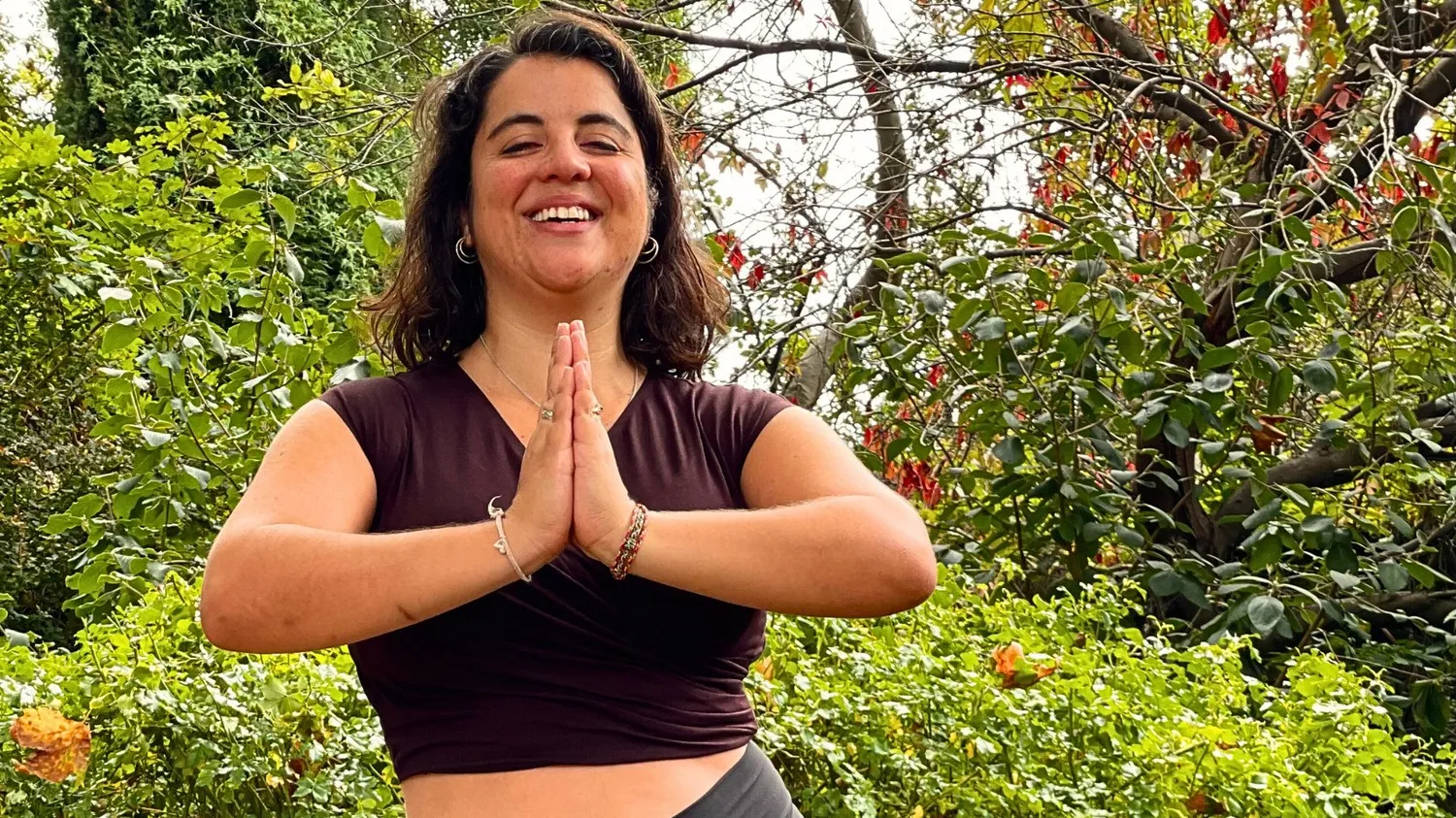 Maria in a yoga pose, hands together at heart centre