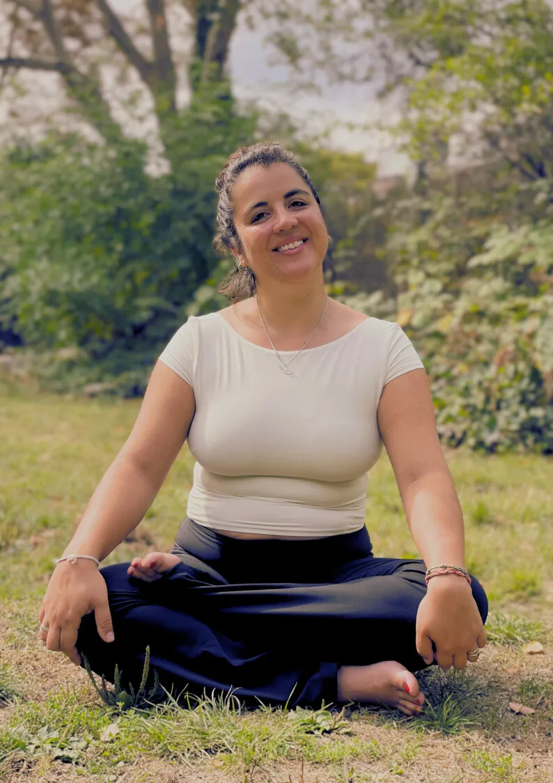 Maria Montserrat seated in lotus pose on the grass