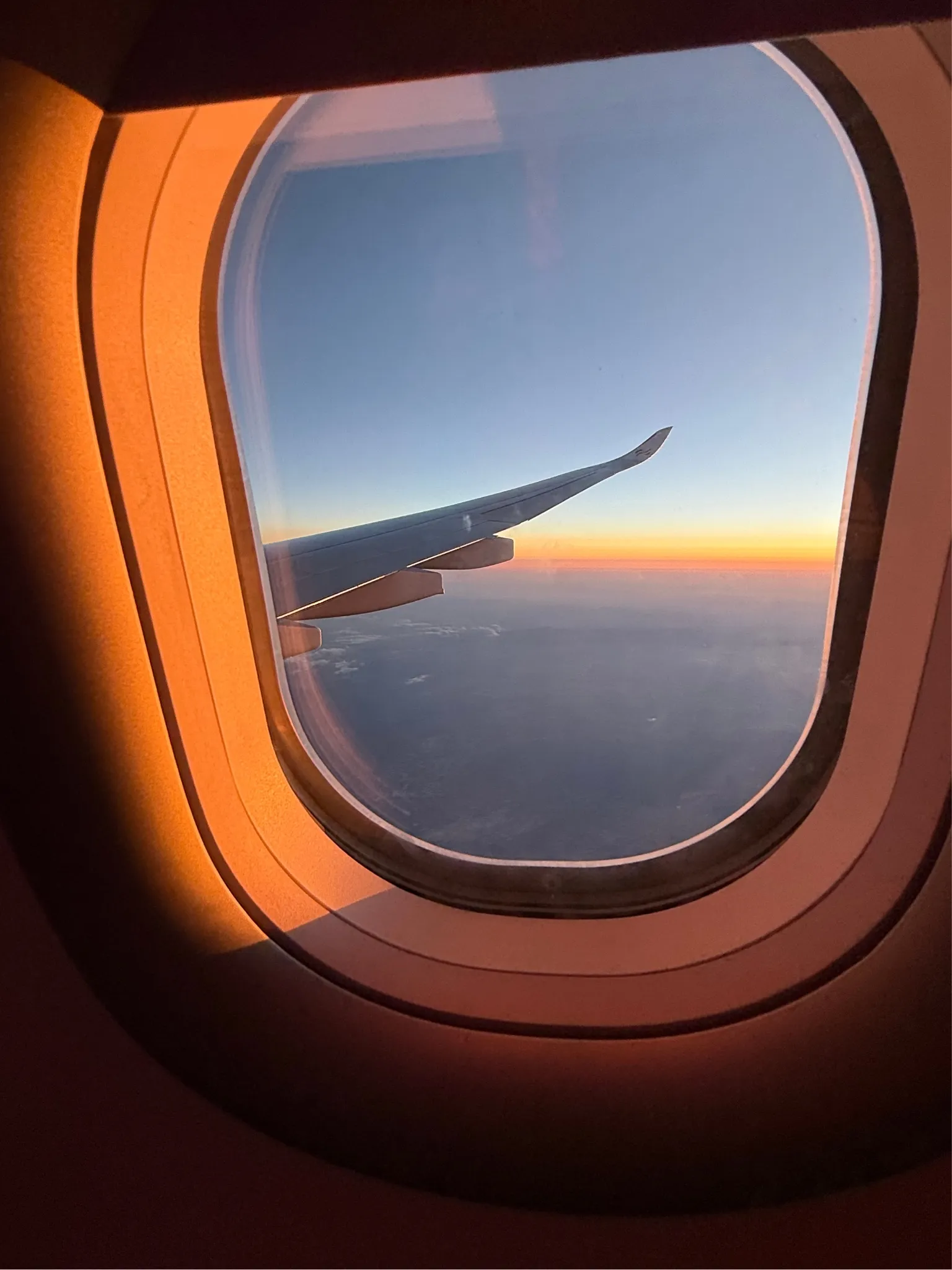 Travel photograph — airplane window at sunset
